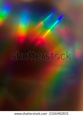 Rainbow prism streaking light rays curving through frame for background or overlay