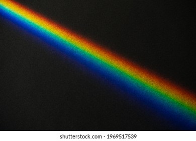 Rainbow Prism Streek On Black Textured Paper Background