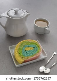 Rainbow Roll Cake On The Plate With Cup Of Tea