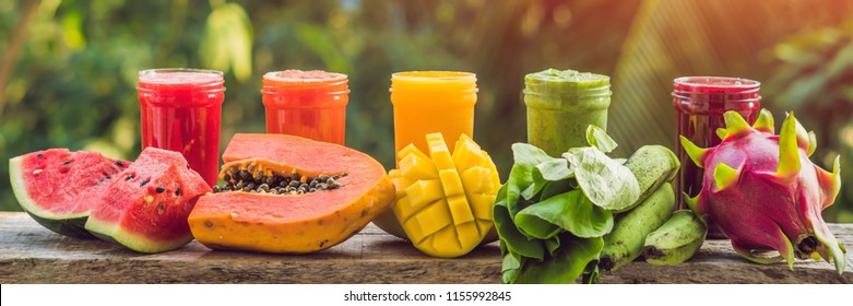Rainbow from smoothies. Watermelon, papaya, mango, spinach and dragon fruit. Smoothies, juices, beverages, drinks variety with fresh fruits on a wooden table BANNER, long format