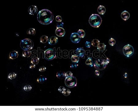 Rainbow soap bubbles on black background.