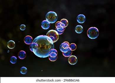 Rainbow soap bubbles on a dark background. - Shutterstock ID 296886146