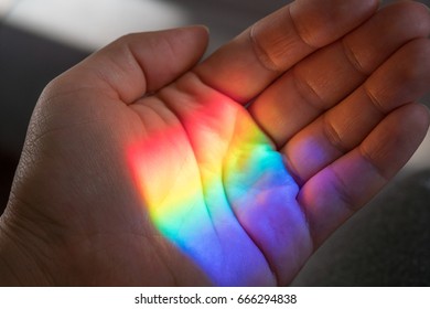 Rainbow sun shine light on a hand