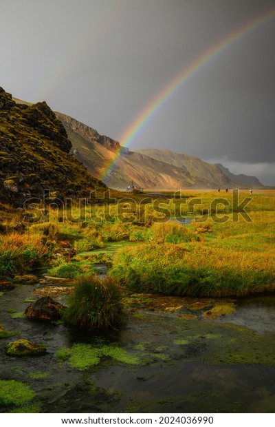 A rainbow at sunset above a pond near\
the Landmannalaugar hut, hot spings and camping sites, Fjallabak\
Nature Reserve, Central Highlands,\
Iceland