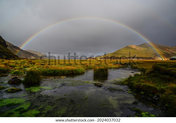 A rainbow at sunset above a pond near\
the Landmannalaugar hut, hot spings and camping sites, Fjallabak\
Nature Reserve, Central Highlands,\
Iceland