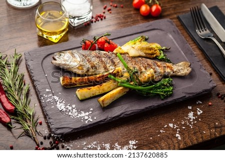 Rainbow trout grilled. Vegetables, white wine sauce. Delicious healthy traditional food closeup served for lunch in modern gourmet cuisine restaurant