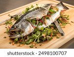 rainbow trout stuffed with the fresh herbs as closeup on a brown board