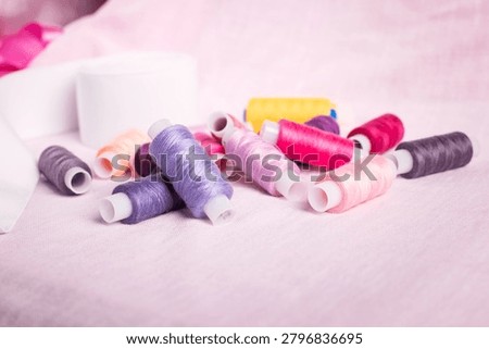 Rainbow-colored thread spools arranged on soft background, sewin