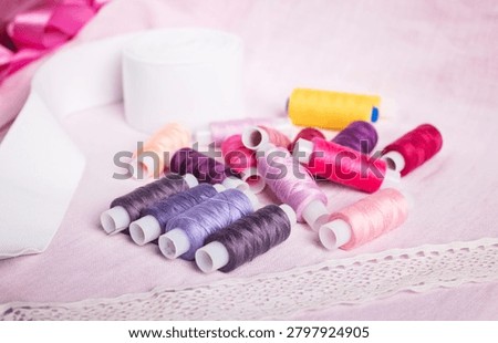 Rainbow-colored thread spools arranged on soft background, sewin