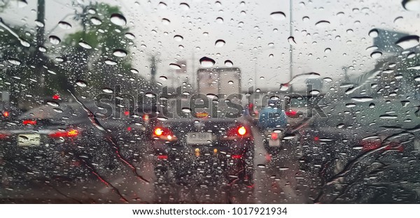 Raindrop on the car glass with blurred background.\
Rain drops on the car glass. Water drops on the car glass. Water\
drops on the glass and traffic jams. Blur background and texture\
traffic on the road
