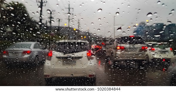 Raindrop on the car glass with blurred background.
Rain drops on the car glass. Water drops on the car glass. Water
drops on the glass and traffic jams. Blur background and texture
traffic on the road