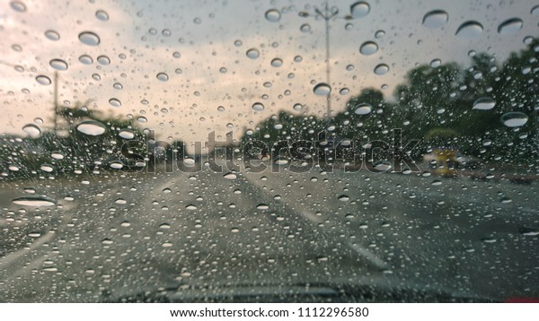 Raindrop on the car\
glass with blurred background. Rain drops on the car glass. Water\
drops on the car glass.\
