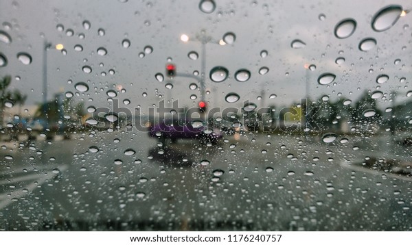 Raindrop on the car glass with blurred background.\
Rain drops on the car glass. Water drops on the car glass. Water\
drops on the glass and traffic jams. Blur background and texture\
traffic on the road