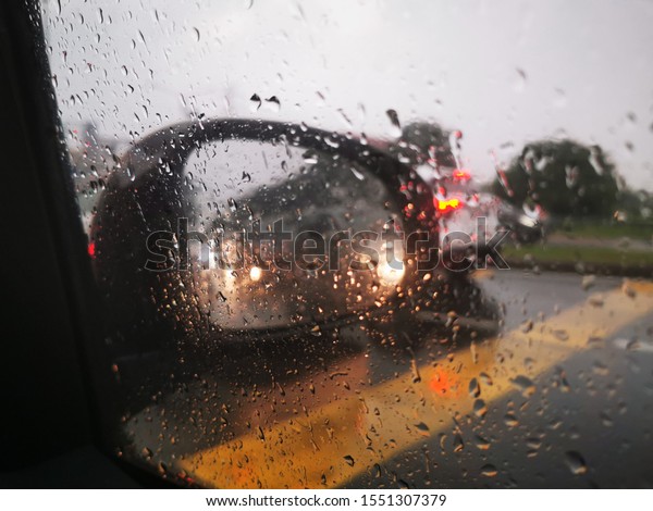 Raindrop on car\
screen during heavy\
traffic.