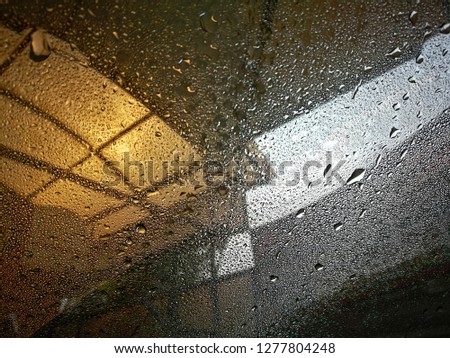 raindrop on car window glass surface, close up abstact volatized water background