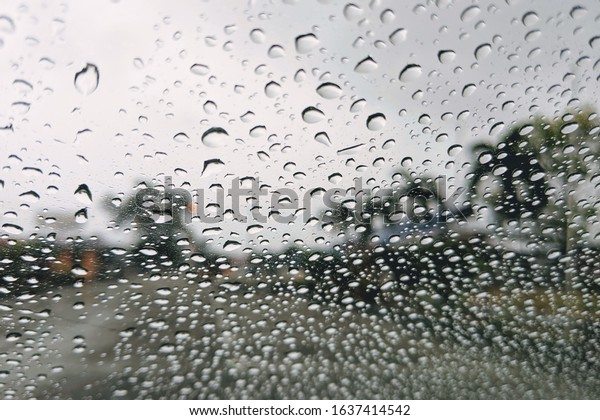 Raindrop on the window car. Abstract blur\
bokeh of traffic and car light. poor view caused by heavy rain and\
back light.\
\

