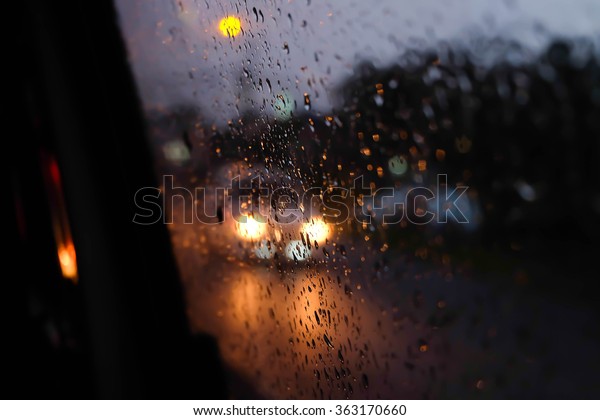 Raindrop on the window at night with car light on\
the street