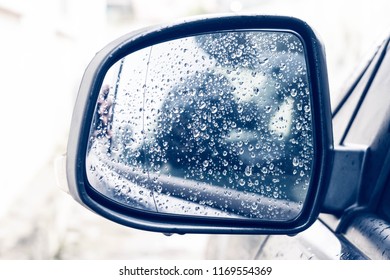 Raindrop outside the car in raining day.  Raindrops on car window and rear view mirror. wing mirror. Morning dew drops on a car side mirror passenger side for raint seaon concept