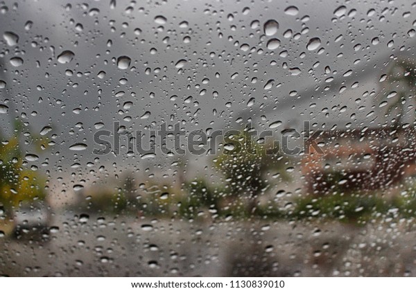 Raindrop outside the car in raining\
day at street. Good view from driver seat during\
travel.