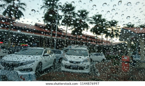 Raindrop outside the car in raining\
day at street. Good view from driver seat during\
travel.