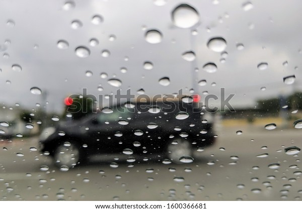 Raindrop outside the car in raining day.\
Good view from driver seat. Selective\
focus.