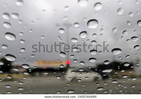 Raindrop outside the car in raining day.\
Good view from driver seat. Selective\
focus.