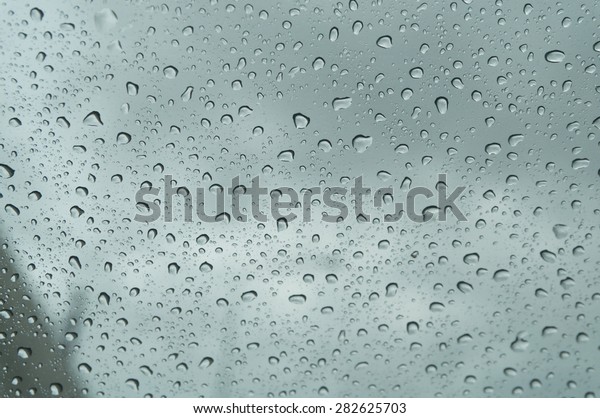 raindrop at\
window that show blur sky  shoot from\
car