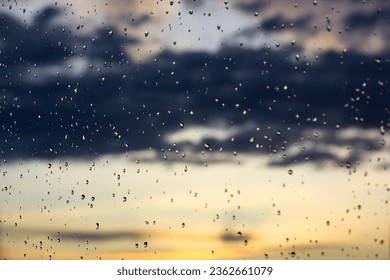 Raindrops background. Overcast weather, rain on a sunny day. Glass surface dotted with lots small water droplets on a rainy day, evening, dusk. Weather forecast for fall. September, October, November. - Powered by Shutterstock