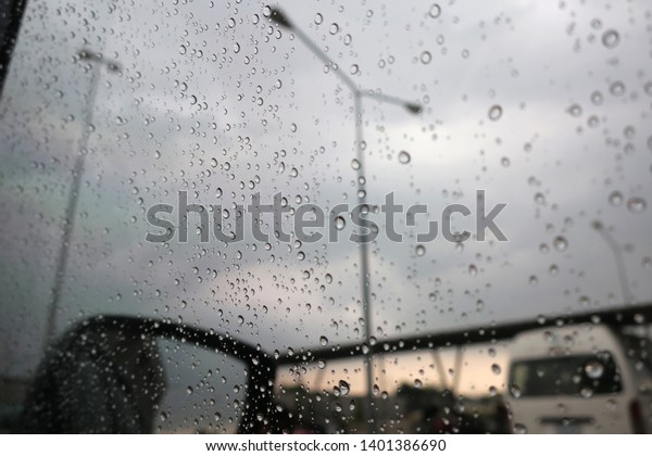 Raindrops at the car glass in the\
evening, asia, bangkok, thailand                             \
