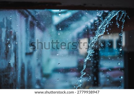 Raindrops cascade down a window, creating a tranquil, moody scene.