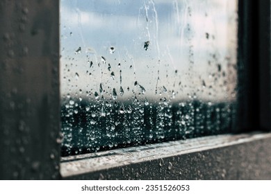 raindrops flow down the window glass. closeup of raindrops