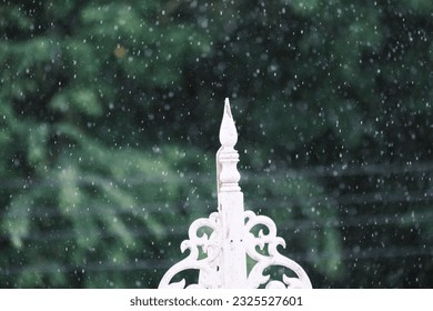 Raindrops gracefully cascade on rooftop, nature's serenade.