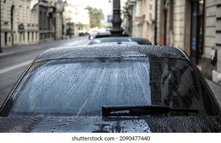 Raindrops On A Back Car Glass. On A Cloudy, Rainy Day, The Back Window And Windshield Wiper Of A Car Are Covered With Drops Of Torrential Rain. Sadness. Melancholy. Bad Weather.