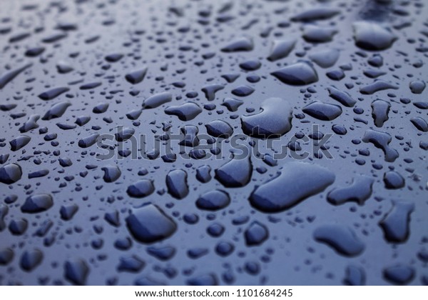 Raindrops on blue bonnet of a\
car