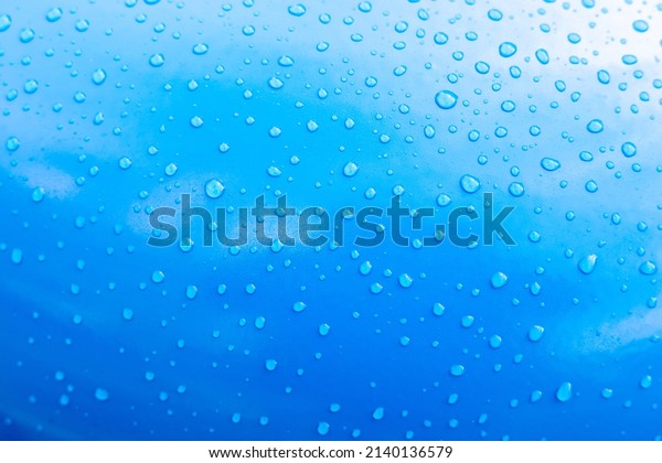 Raindrops on a blue car, close-up. Lots of\
water drops on blue paint. Calming background, element for design.\
Blank for design or\
wallpaper