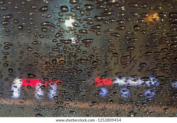 Raindrops on car glass at\
night