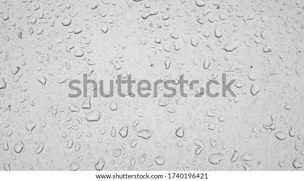 raindrops on car glass, texture of water drops on\
a dusty window. Textured effect background wallpaper backdrop,\
black and white raindrops\
weather