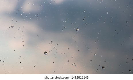 Raindrops On The Glass With The Sky Background.