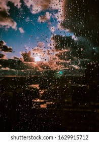 Raindrops On The Glass Of Window Against The Sky With Clouds. The Sun After The Rain. Amazing View
