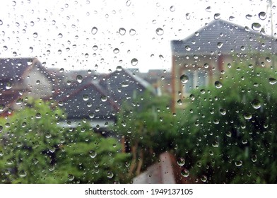 Raindrops On The Glass Window With Blurry Home Residents And Trees Background, In Yogyakarta, Indonesia, April 2021