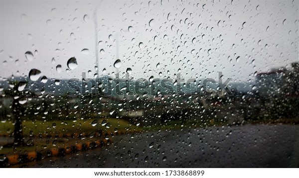 raindrops on the glass window of car, blurred mountain\
scene on background 