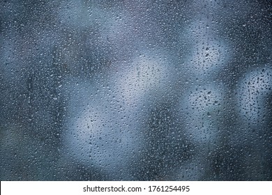 Raindrops On Glass Of Window With Dark Green Nature Blurred In Background, Rain Droplets On Window During The Big Storm.