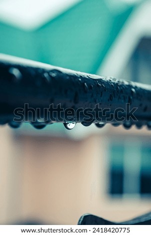 Raindrops on iron pipe, closeup. Raindrops on an iron pipe fence on a balcony in a private house