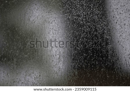 raindrops on plexiglass window of cottage deck view of tree and forest through wet transparent window creating painterly effect on outdoor view of large tree horizontal format room for type background 商業照片 © 