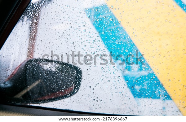 Raindrops on the side window of a car, Close up of\
raindrops on the window of a car, Macro of drops of water on the\
windows of a car.