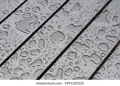 Raindrops on the surface. Water on the surface. After the rain. Water drops. Wooden boards.