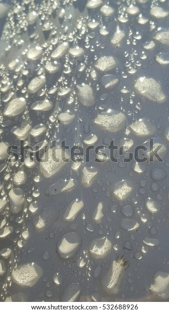 Raindrops on white metallic\
surface