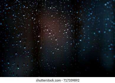 Raindrops on window with blurred background.