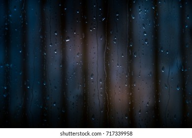 Raindrops on window with blurred background.