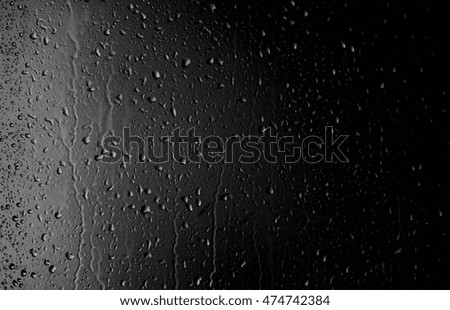 Raindrops on the window on the dark background